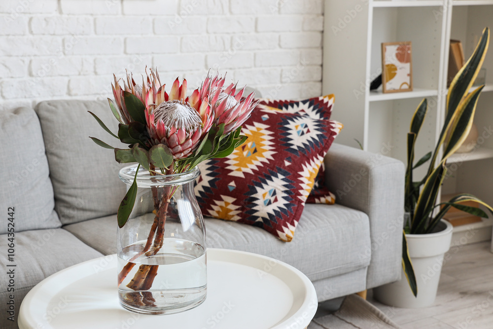 Vase with protea flowers on table in living room, closeup