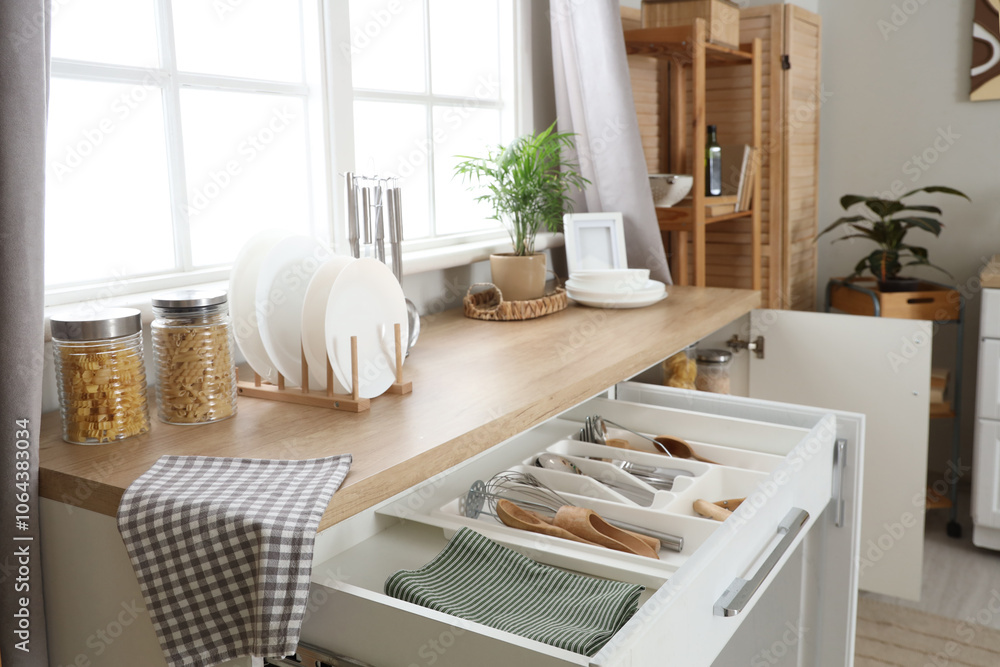 Counters with open drawers and utensils in kitchen