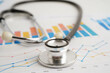 © manassanant - Stethoscope on chart or graph paper, Financial, account, statistics and business data medical health.