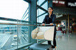 © zhouyilu - Confident Woman Pushing Luggage Cart at Modern Airport Terminal