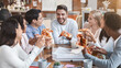 © Prostock-studio - Young multiracial coworkers having lunch in office, eating pizza