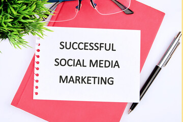 The concept of business and development. The conceptual method, once, the word SUCCESSFUL SOCIAL MEDIA MARKETING on a white sheet of paper, top view