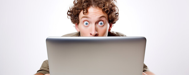Fototapete - Surprised man with curly hair reacts while staring at a laptop screen in a bright setting during daytime