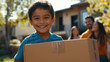 © Frank Gärtner - Happy boy bringing cardboard box into new home as his family looks on, representing real estate and moving concept