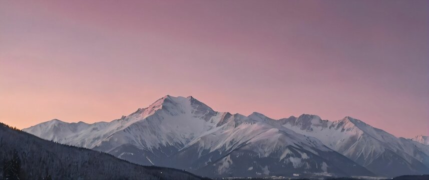 A snowy mountain range at dawn with a pink hued sky