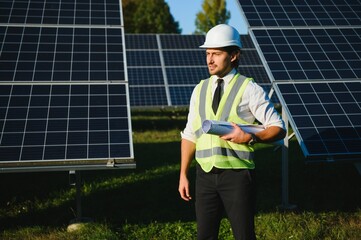 Businessman or engineer standing near solar panels