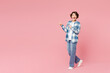 © ViDi Studio - Full body young shocked surprised woman wear blue shirt white t-shirt casual clothes walk go point index finger aside on area isolated on plain pastel light pink background studio. Lifestyle concept.