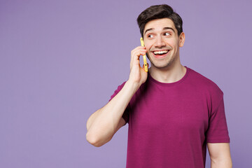 Wall Mural - Young Caucasian man he wear violet t-shirt casual clothes talk speak on mobile cell phone conducting pleasant conversation isolated on plain pastel light purple background studio. Lifestyle concept.