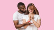 © Prostock-studio - Surprise Proposal. Romantic Black Guy Covering Eyes And Giving Engagement Ring To His Excited Girlfriend, Yellow Background With Copy Space