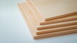 © Newvie - Stack of smooth maple wood panels on a soft white background.