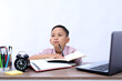 © ArvStd - Asian schoolboy studying and thinking looking up on the desk. Isolated on white background