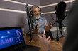 © ReeldealHD images - Podcaster recording a podcast in a studio gesturing with hands