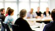 © N7 - Team Meeting Blur - Fuzzy background of a team meeting around a large conference table.