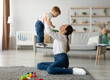 © Prostock-studio - Unconditional love. Happy young mother enjoying time with her adorable toddler son at home, lifting him in the air, playing with kid boy in living room, free space