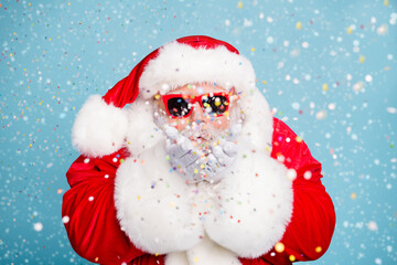 Wall Mural - close-up portrait of his he nice fat dreamy bearded santa st saint nicholas blowing decorative confe
