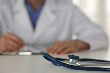 Doctor working at table, focus on stethoscope