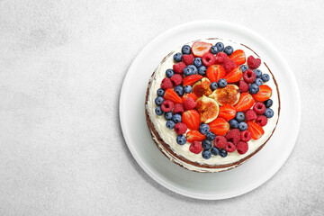 Wall Mural - Delicious chocolate sponge cake with berries on light table, top view. Space for text
