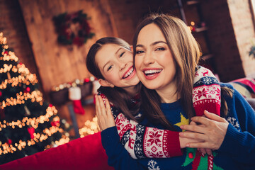 Photo of two peaceful people mother daughter embrace have good mood new year xmas apartment indoors