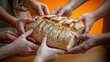 © Vladimir - Hands sharing a fresh loaf of bread.