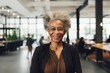© CojanAI - Portrait of a smiling senior African American businesswoman in modern office