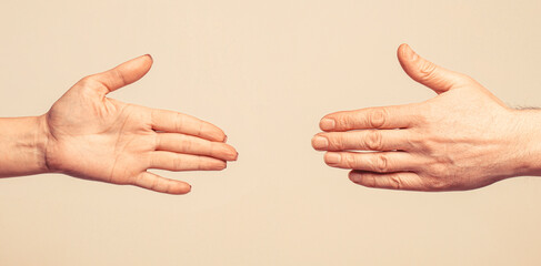 Wall Mural - Rescue, helping gesture or hands. Hands man and woman reaching to each other, support. Giving a helping hand. Hands of man and woman on gray background