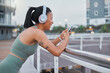 © peopleimages.com - Woman, happy and fitness in city with phone, music streaming and social media on break. Sports influencer, smile or mobile on Puerto Rico street for rest, progress app and follower interaction on run