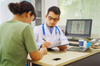 © NanSan - A male doctor sits at a desk in a hospital,reviewing a female patient’s medical history.He provides compassionate advice for depression, addressing symptoms like sadness,hopelessness, anger, anxiety