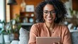 © Atiyut - A woman with curly hair is smiling and holding a tablet
