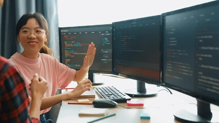 Slow motion back end software developer engineer for computer programming working together on debugging writing computing code, solving complex algorithms display on monitor in office. Burgeoning