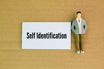 miniature people and white paper with the word self identification. defining one's own identity based on personal, social, and cultural aspects