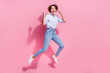 © deagreez - Full body portrait of overjoyed pretty lady jump raise fists achievement empty space isolated on pink color background