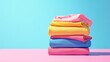 © DigitalDruid - Vibrant stacked garments on a pink and blue backdrop featuring ample copy space