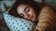 © BloomArt - A young woman sleeping peacefully in bed, her face relaxed and serene.