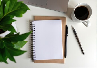 notepad, notebook, pens, cup of coffee and green plant on the white table