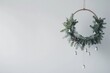 © Mykola - Merry Christmas Round: Modern Christmas Wreath Hanging on White Wall Background