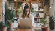 © Galib - A young woman in a white shirt and glasses working on her laptop in a home office setting.
