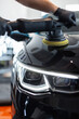 © alones - man with a polishing tool polishes a black car in a detailing studio. Car care. Car Buffers and Polishers