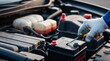 © PabloStock - Close-up of gloved hand holding screwdriver while working on car battery in an automotive repair
