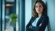 © Tadeusz - Confident young woman in a business suit poses in modern office setting.