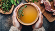 © Natalia Klenova - Hands Holding a Warm Bowl of Bone Broth with Herbs