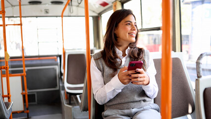 Young woman surfing the net while traveling through the city on a bus