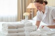 © Anna - Smiling housekeeper organizing fresh towels in a bright hotel room