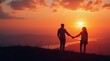 © Alex Pios - Silhouette of a couple standing hand in hand on a hilltop during sunset, with a breathtaking view of the landscape below and a colorful sky, creating a romantic and serene atmosphere