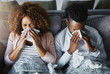© peopleimages.com - Sick couple, sneeze and blowing nose with tissue on sofa for allergy, virus or flu and cold together above at home. Top view, young man and woman with influenza for sinus, symptoms or fever season