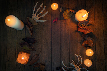 space for Invitation to a costume night with a Halloween atmosphere. skeleton hand, autumn leaves, candles and feeling of fun and mystery.