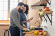 © InsideCreativeHouse - Joyful young mixed race couple african woman arabian man using online app on tablet cooking together in home kitchen ordering food delivery on supermarket store internet website consulting recipe
