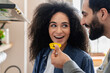 © InsideCreativeHouse - Caring husband feed his beloved mixed race wife, happy loving couple standing in modern domestic kitchen enjoy romantic dating . House-warming event, romance concept