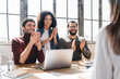 © InsideCreativeHouse - Young business woman sharing creative ideas a meeting in a modern office while others are applauding . Multicultural group of innovative businesspeople having a discussion working a new project.