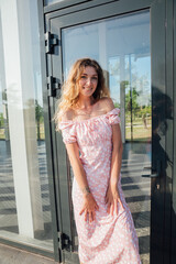 Beautiful woman smiling in summer dress in park walking