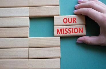 Our Mission symbol. Concept word Our Mission on wooden blocks. Businessman hand. Beautiful grey green background. Business and Our Mission concept. Copy space